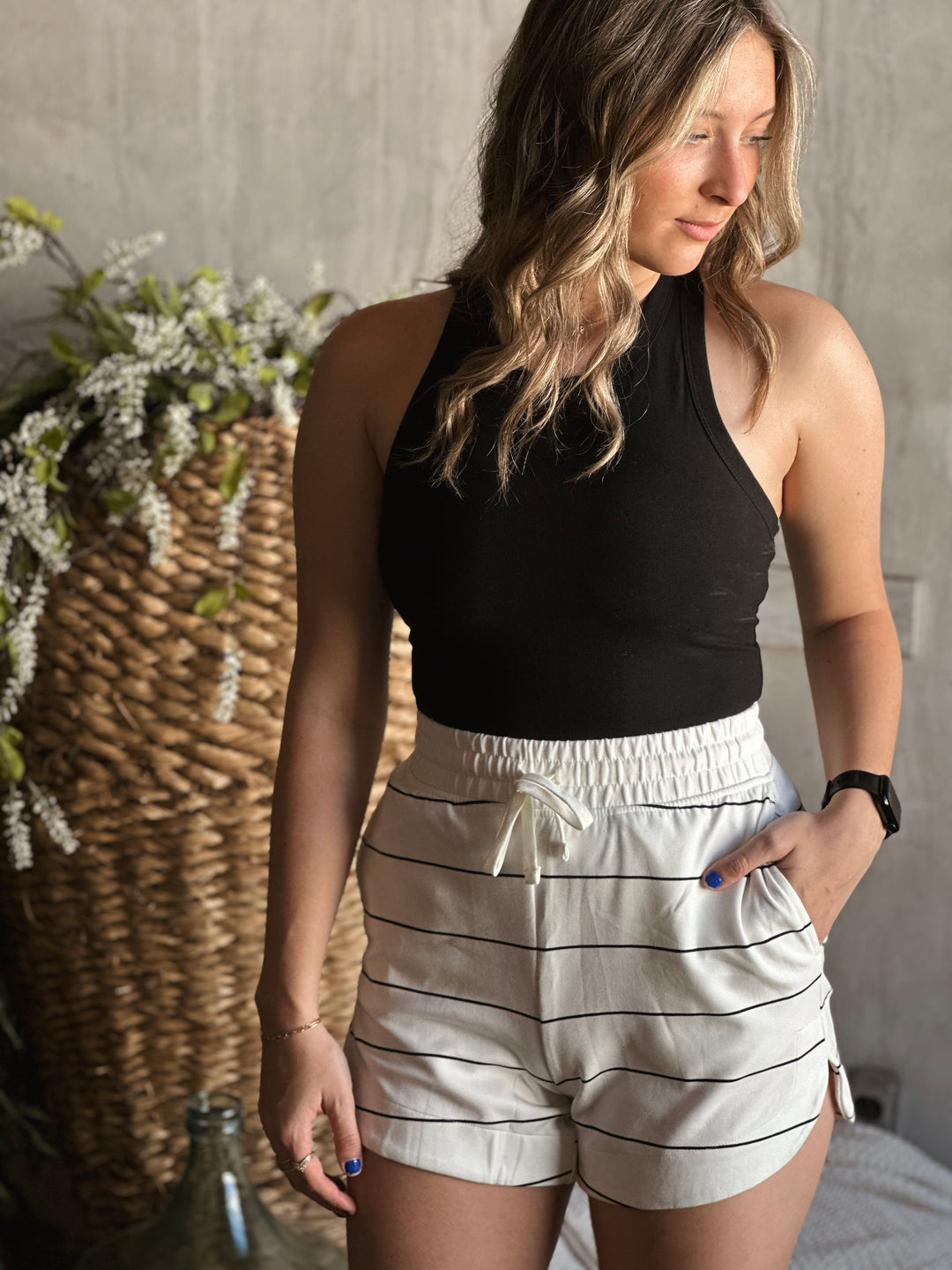 Front view of model wearing a butter soft racerback tank top in the color black