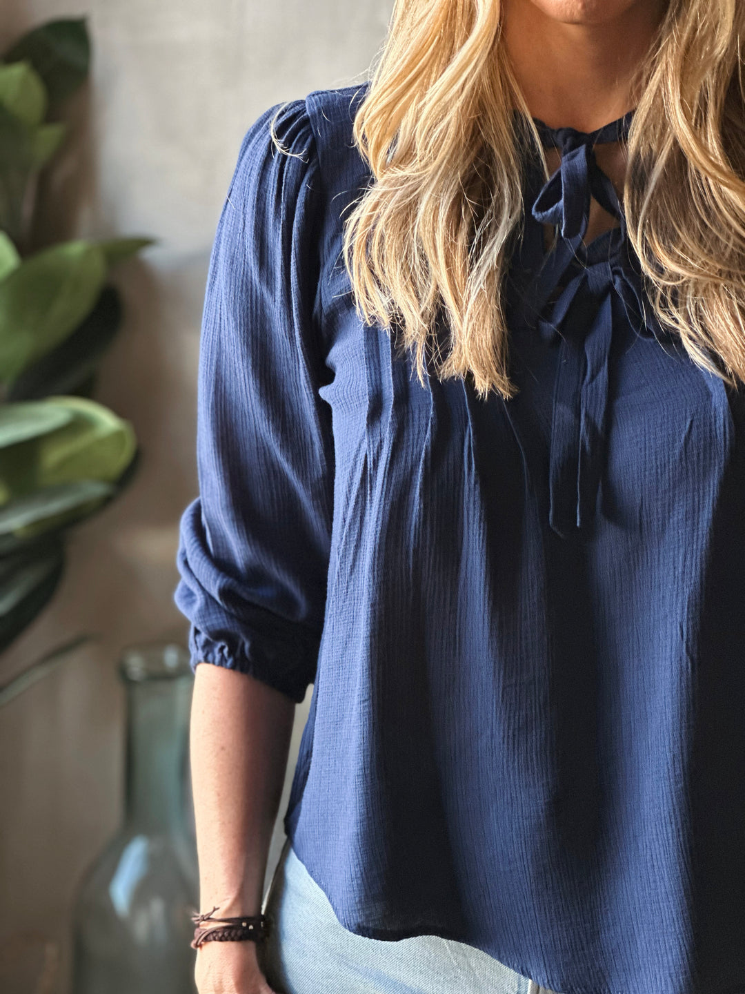 Person wearing a blue blouse with a blurred background