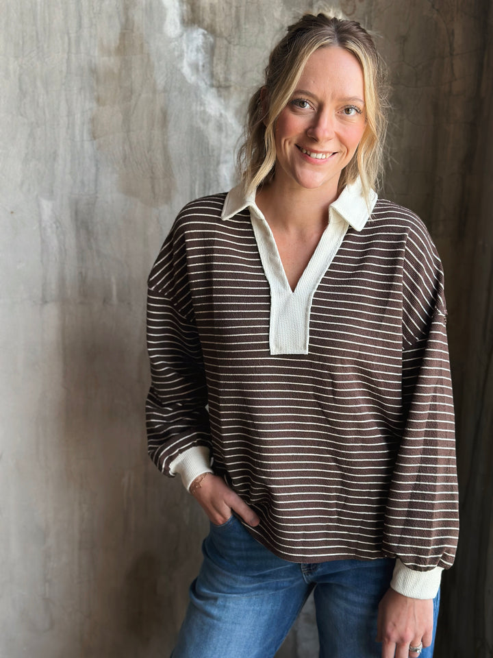Woman wearing a brown and white striped shirt with a plain background