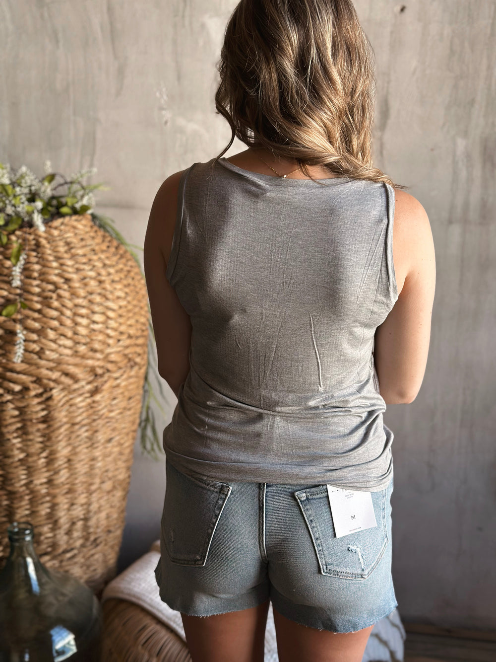 Back view of model wearing a ribbed textured knit tank top with a scoop neckline sleeveless design in the color gray