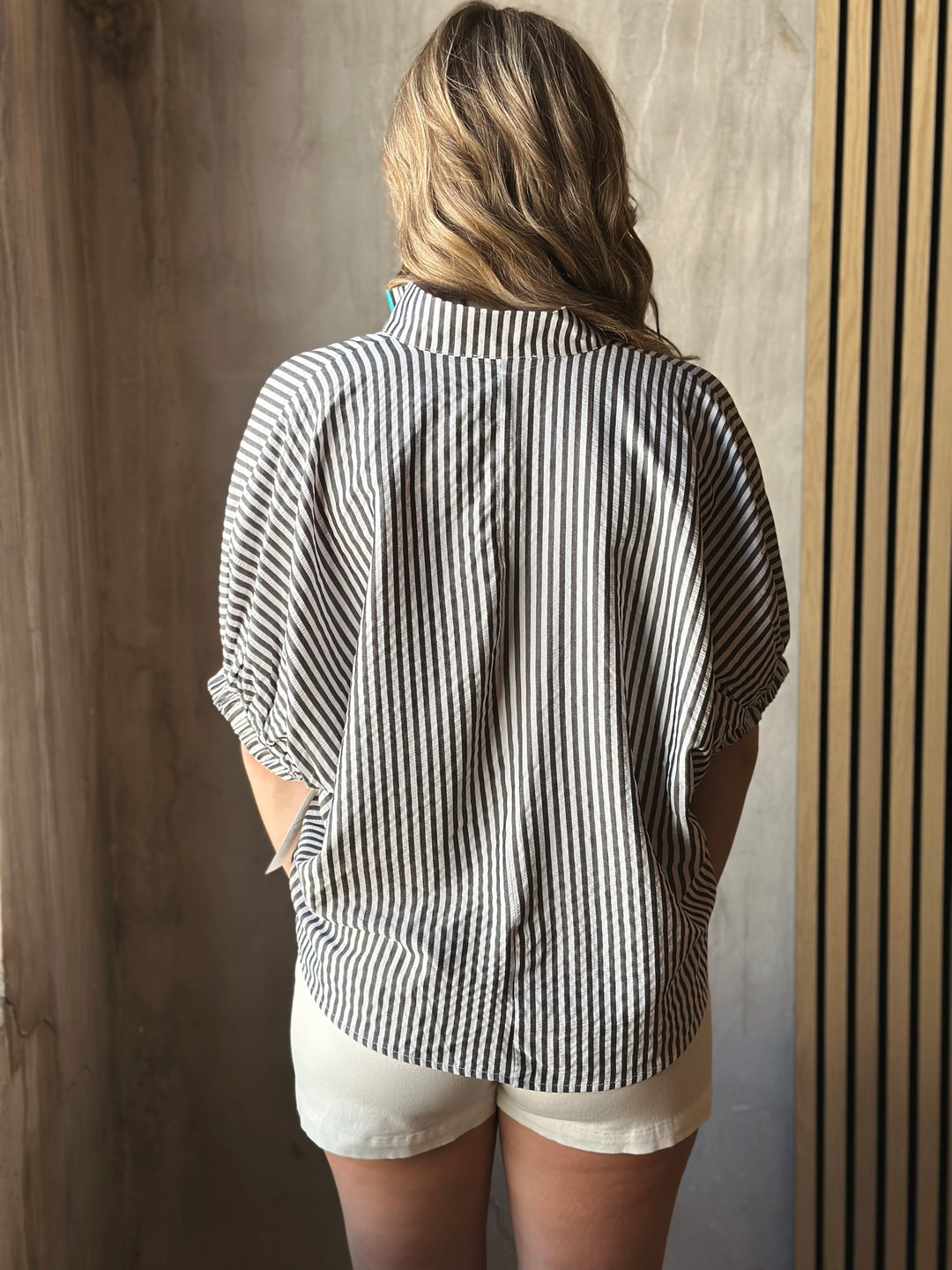 Backview of model wearing a striped high neck dolman short sleeve top.