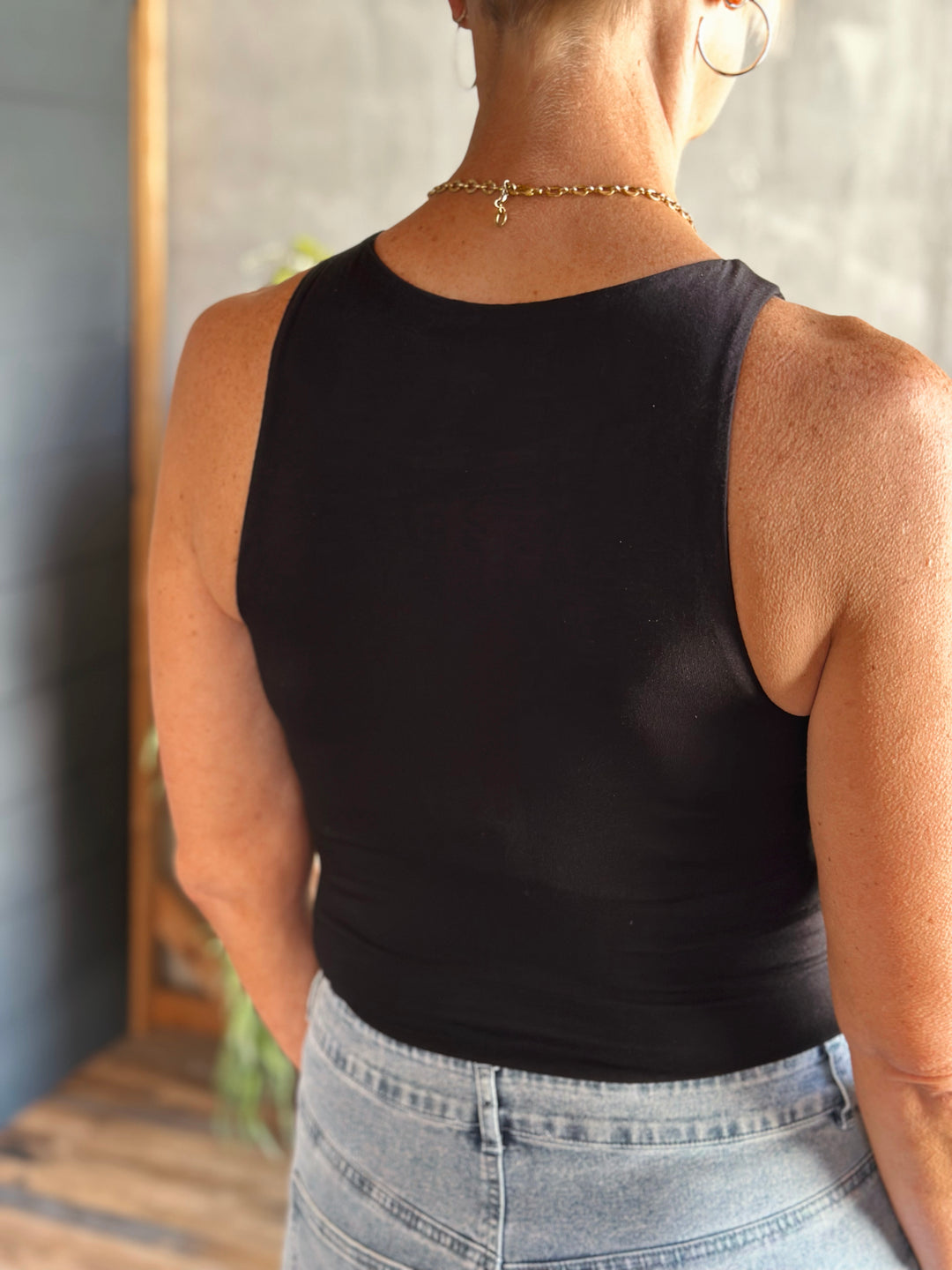 back view of Black fitted bodysuit round neckline and tank straps