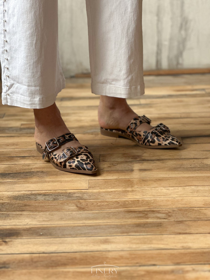 Front view of flat sandals that are closed toe with a cheetah print design, and two straps that have buckles on them