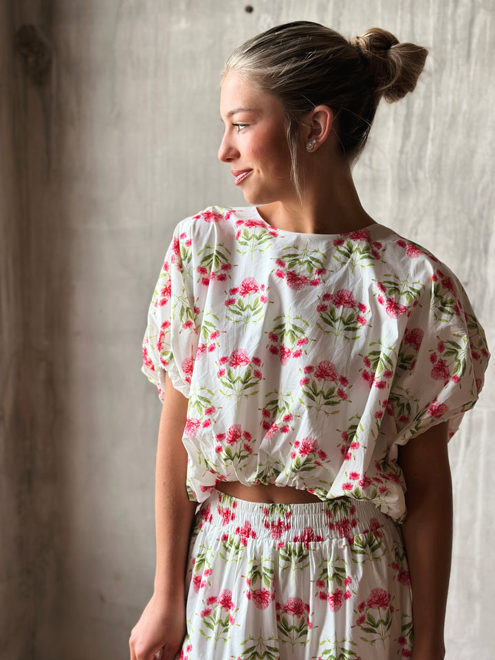 Front of floral print pullover top features a flattering bubble hem and a waist-length cut.