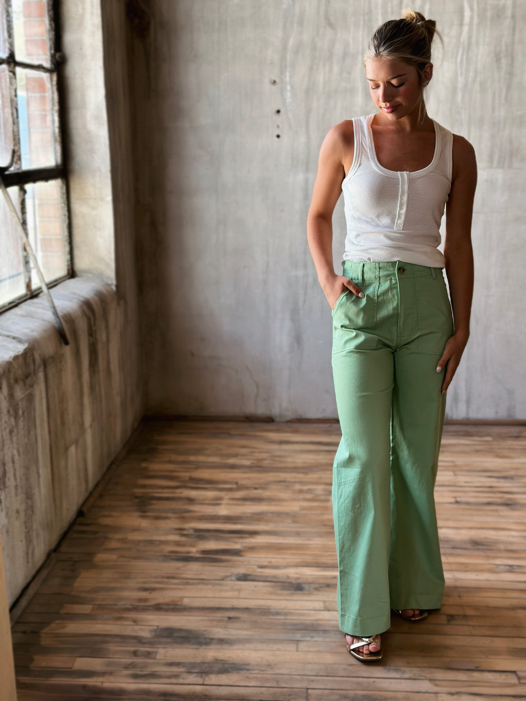 full front view of white Button Down Fitted Knit Tank Top and green pants