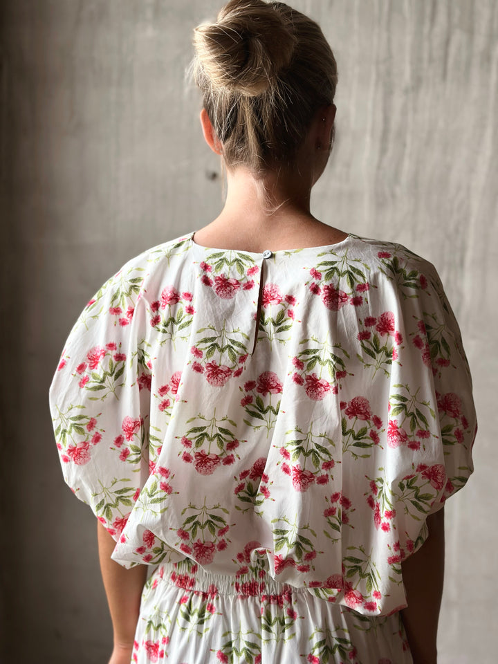 Back of floral print pullover top features a flattering bubble hem and a waist-length cut.