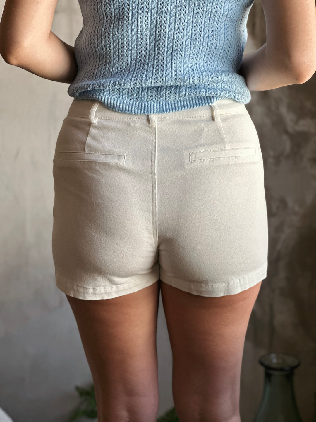 Back view of high waist white shorts, with lap pockets.