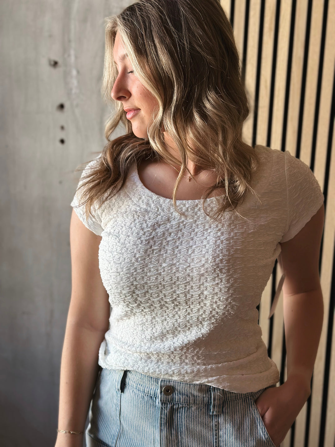 Front view of model wearing Popcorn Textured Knit Double Scoop Neckline Cap Sleeve Top in the color white