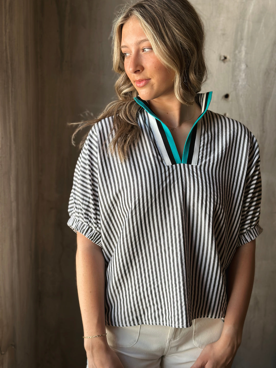 Front view of model wearing a striped high neck dolman top. The multicolor rib band split neck adds a touch of playful contrast.