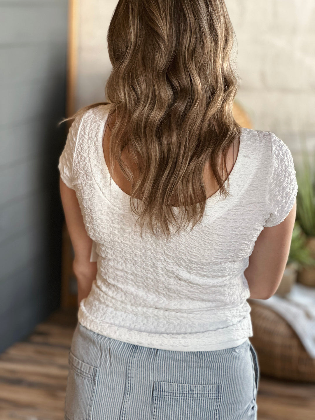 Back view of model wearing Popcorn Textured Knit Double Scoop Neckline Cap Sleeve Top in the color white