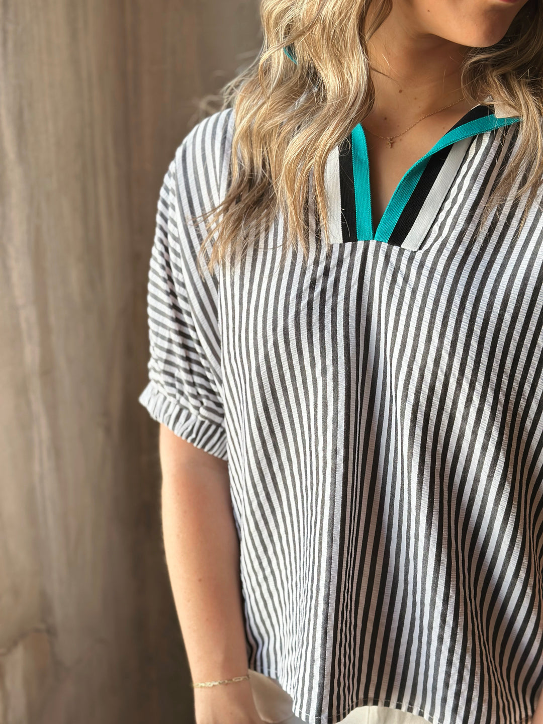 Front view of model wearing a striped high neck dolman top. The multicolor rib band split neck adds a touch of playful contrast.