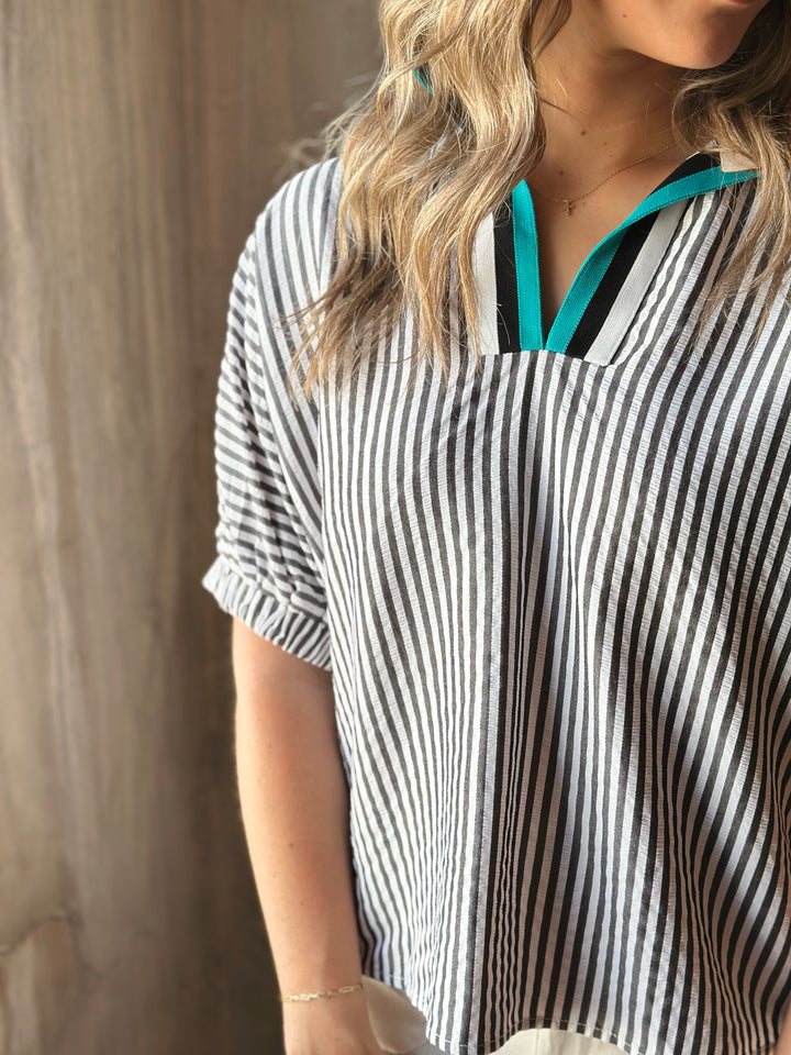 Front view of model wearing a striped high neck dolman top. The multicolor rib band split neck adds a touch of playful contrast.