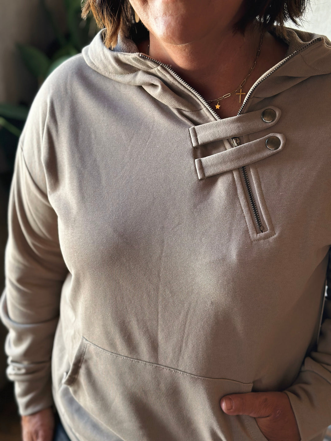 Beige hoodie with a unique front design worn by a person