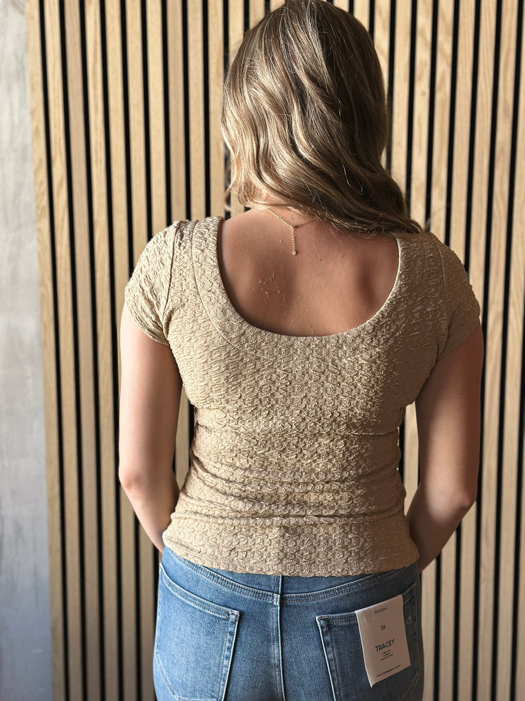 Back view of model wearing Popcorn Textured Knit Double Scoop Neckline Cap Sleeve Top in the color sand