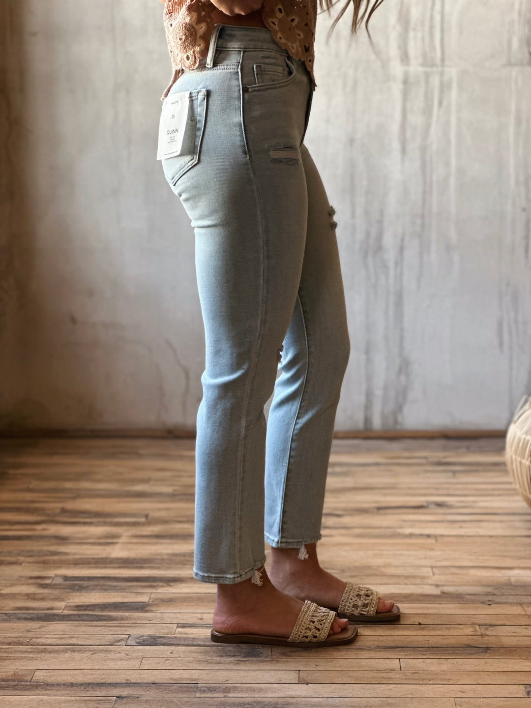 side view of model wearing high-rise cigarette skinny jeans in a classic light blue wash.