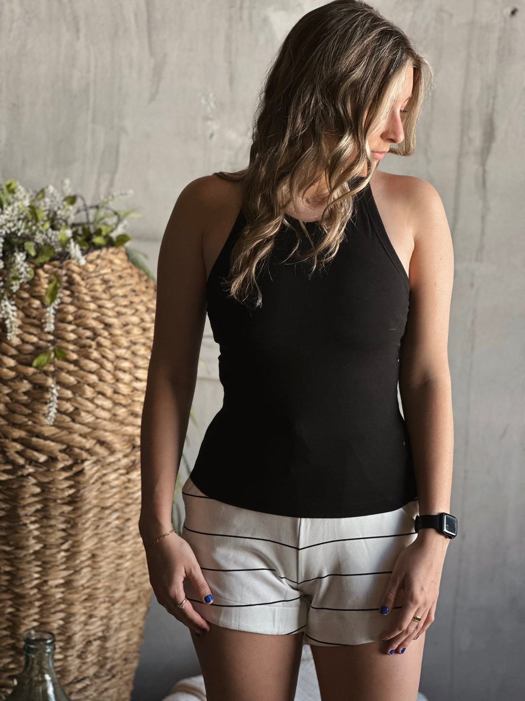 Front view of model wearing a butter soft racerback tank top in the color black