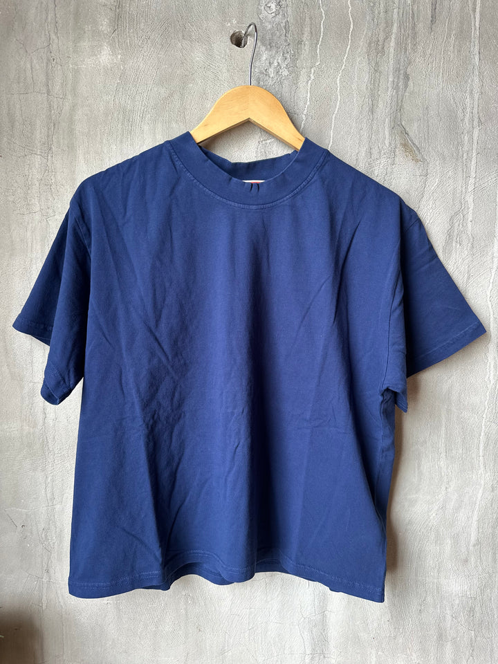 Blue shirt on a wooden hanger against a gray wooden floor background