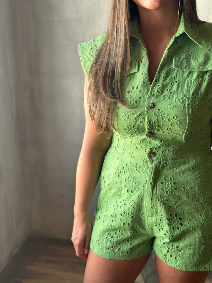 Person wearing a green lace outfit against a neutral background