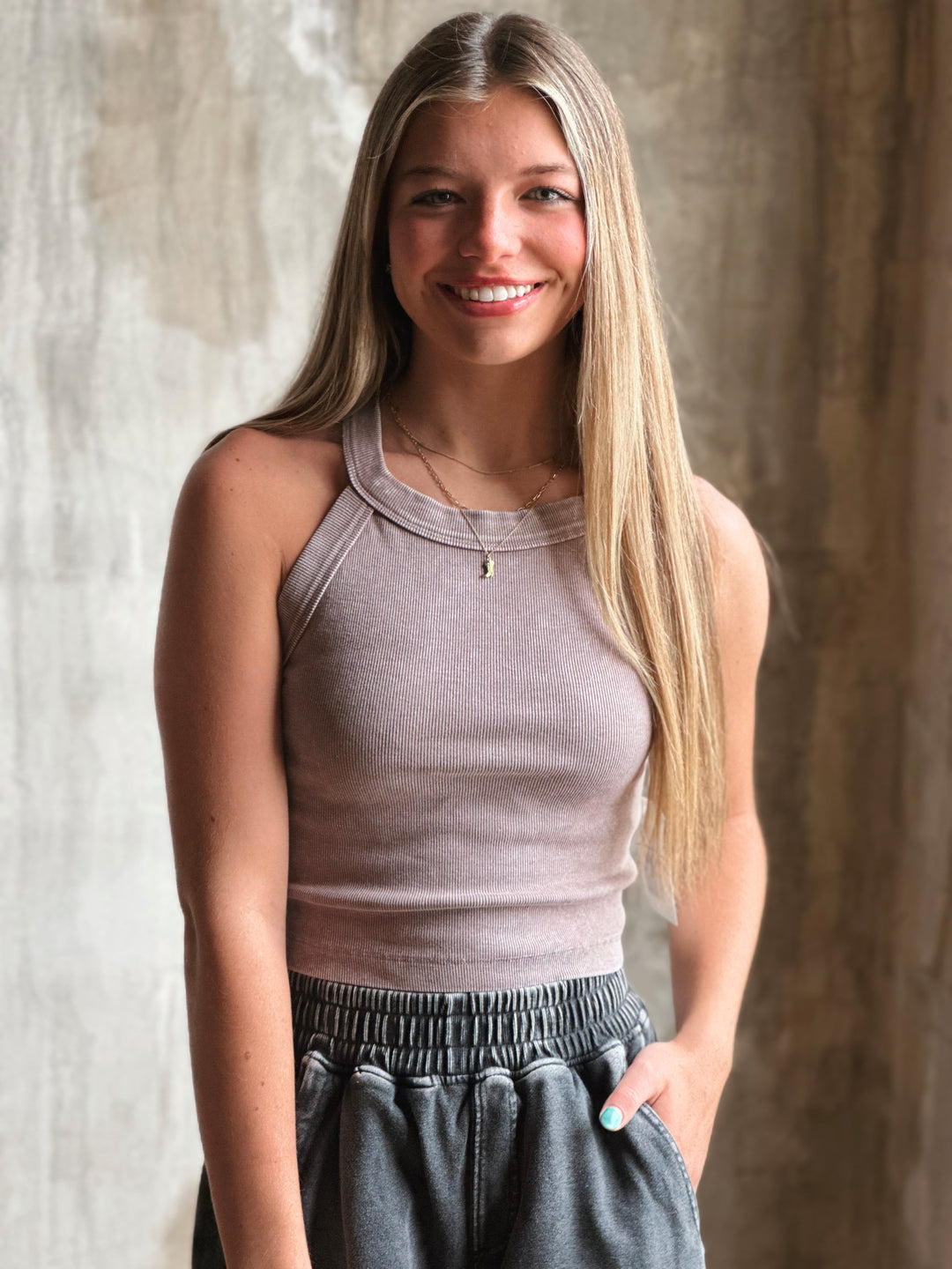 Front view of model wearing a mineral-washed halter neck tank sporty racerback cut and soft, ribbed fabric in mocha