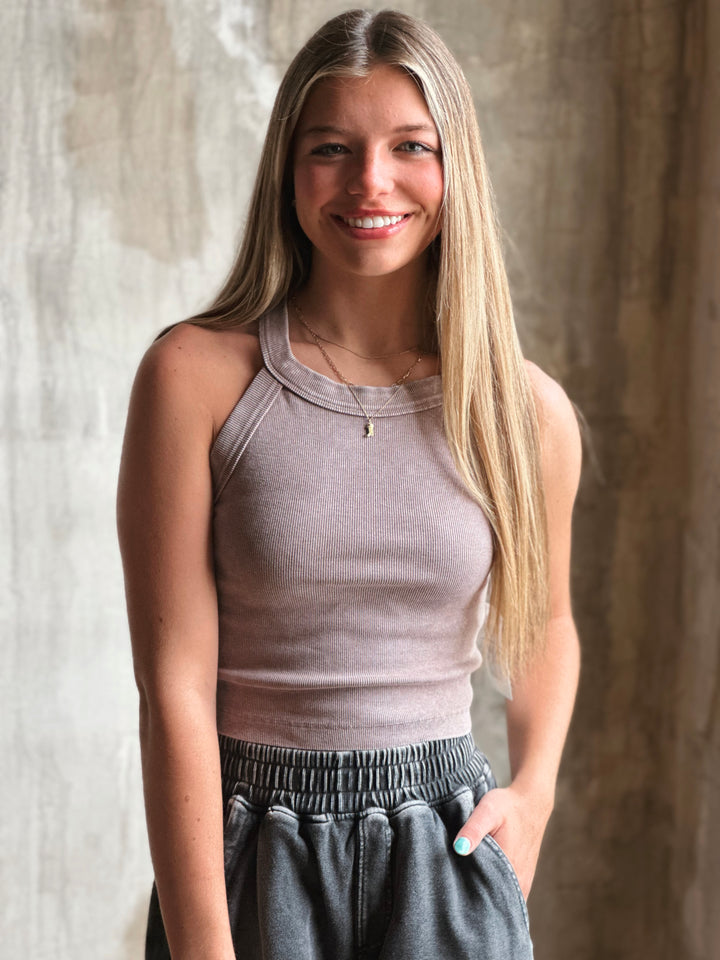 Front view of model wearing a mineral-washed halter neck tank sporty racerback cut and soft, ribbed fabric in mocha