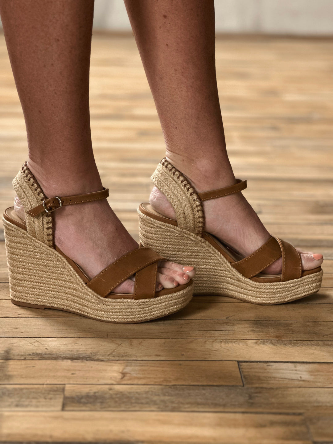 Side view of brown 4 inch wedge sandals, with a woven rapped midsole and an adjustable strap