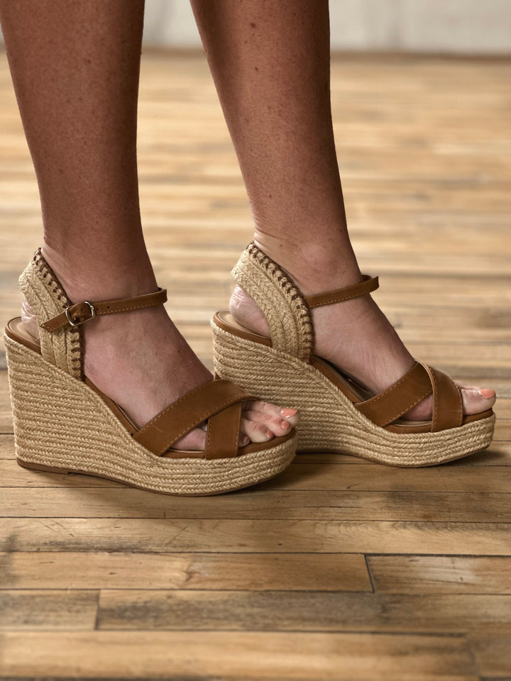 Side view of brown 4 inch wedge sandals, with a woven rapped midsole and an adjustable strap