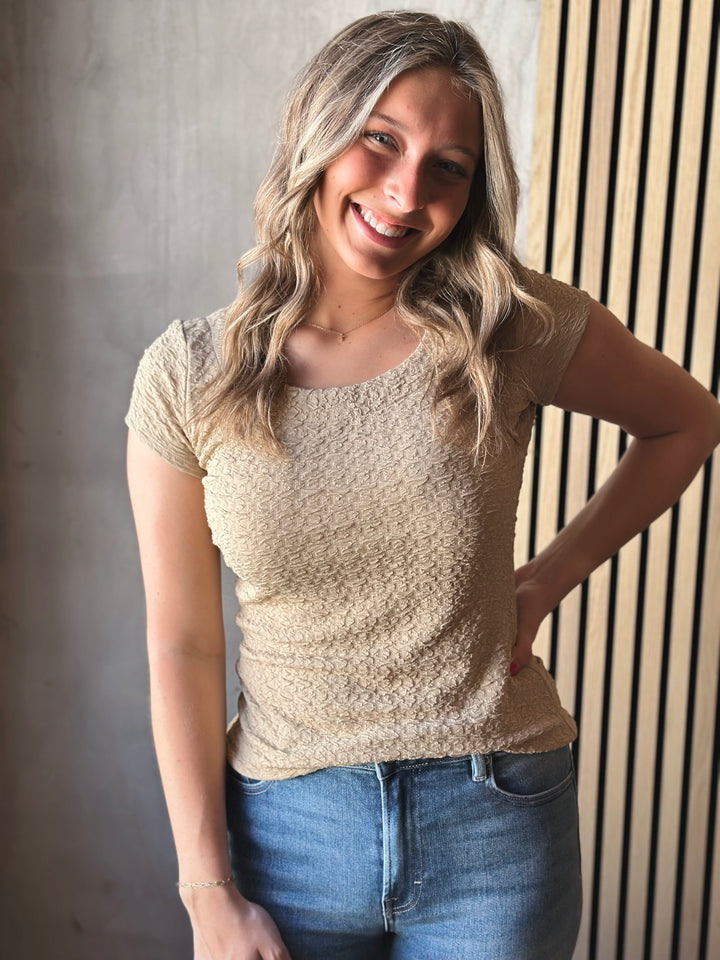 Front view of model wearing Popcorn Textured Knit Double Scoop Neckline Cap Sleeve Top in the color sand