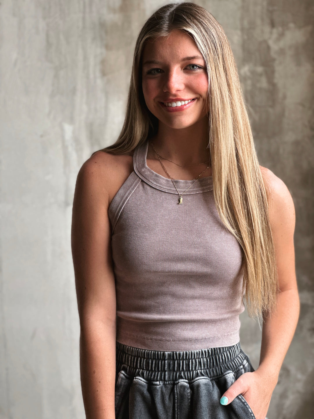 Front view of model wearing a mineral-washed halter neck tank sporty racerback cut and soft, ribbed fabric in mocha