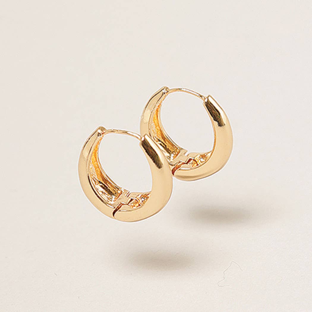 Gold hoop earrings on a light beige background