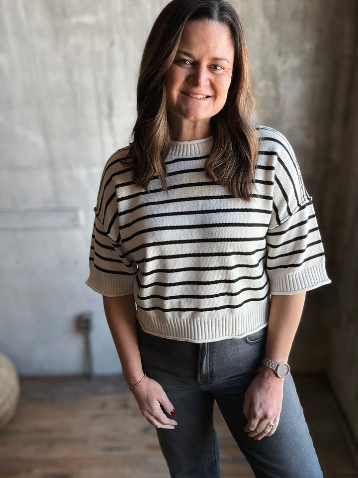 Woman wearing a black and white striped sweater in a casual setting