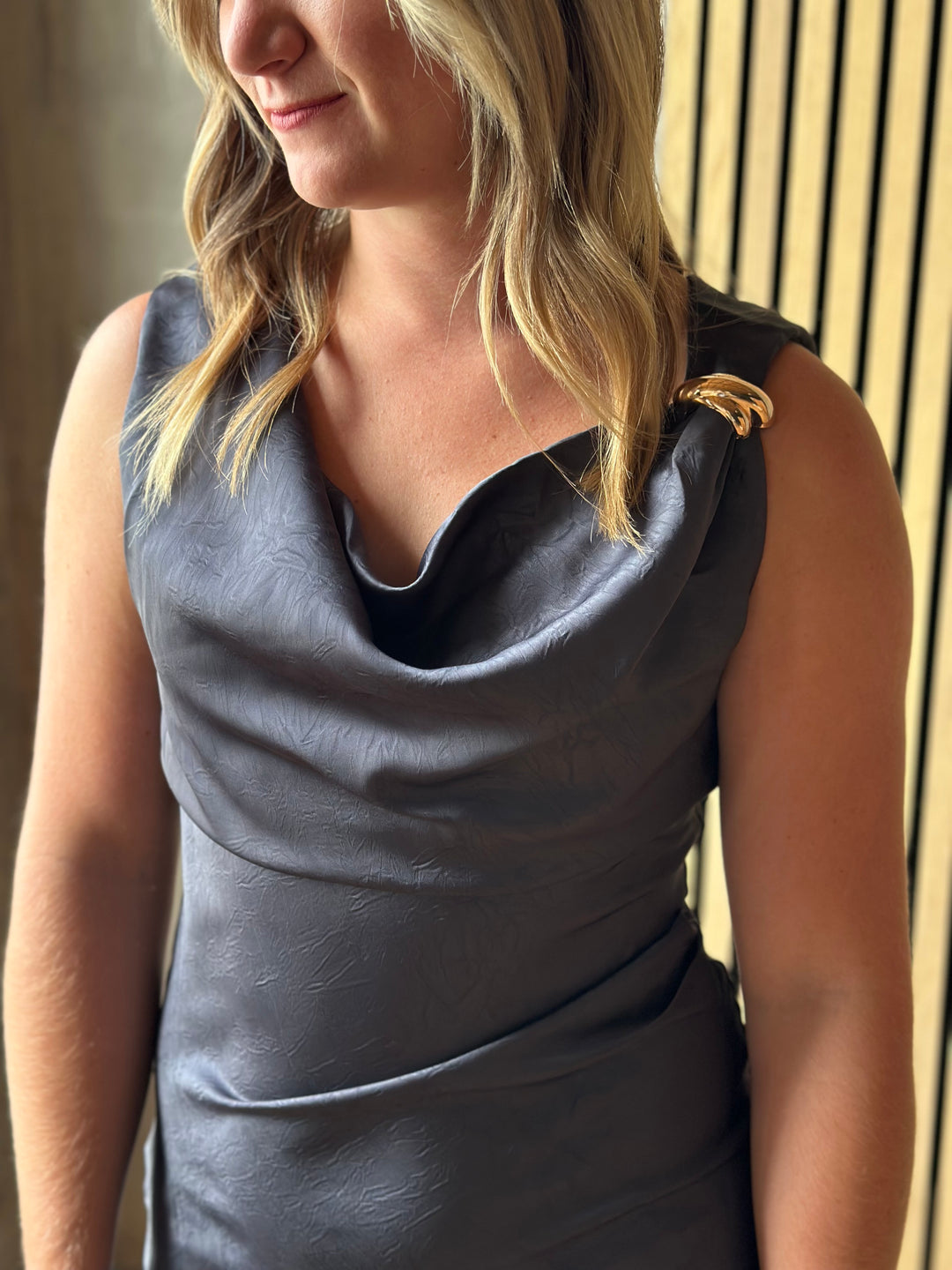 Close-up of a slate gray satin cowl-neck dress
