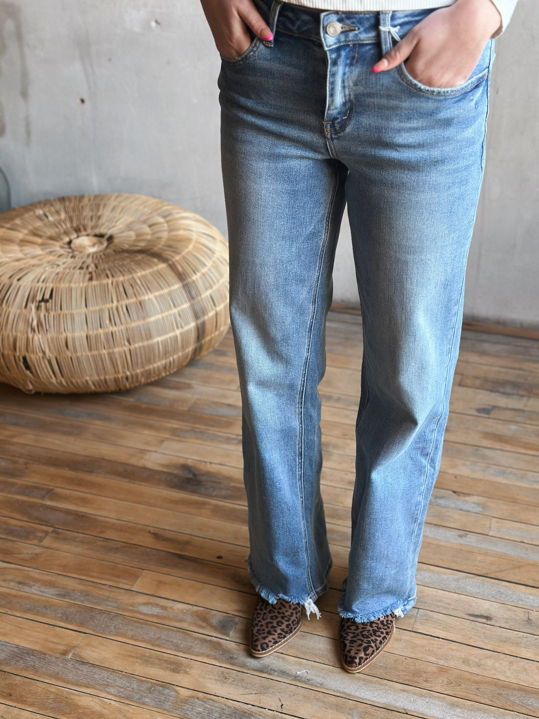 A person wearing light blue jeans with leopard print boots.
