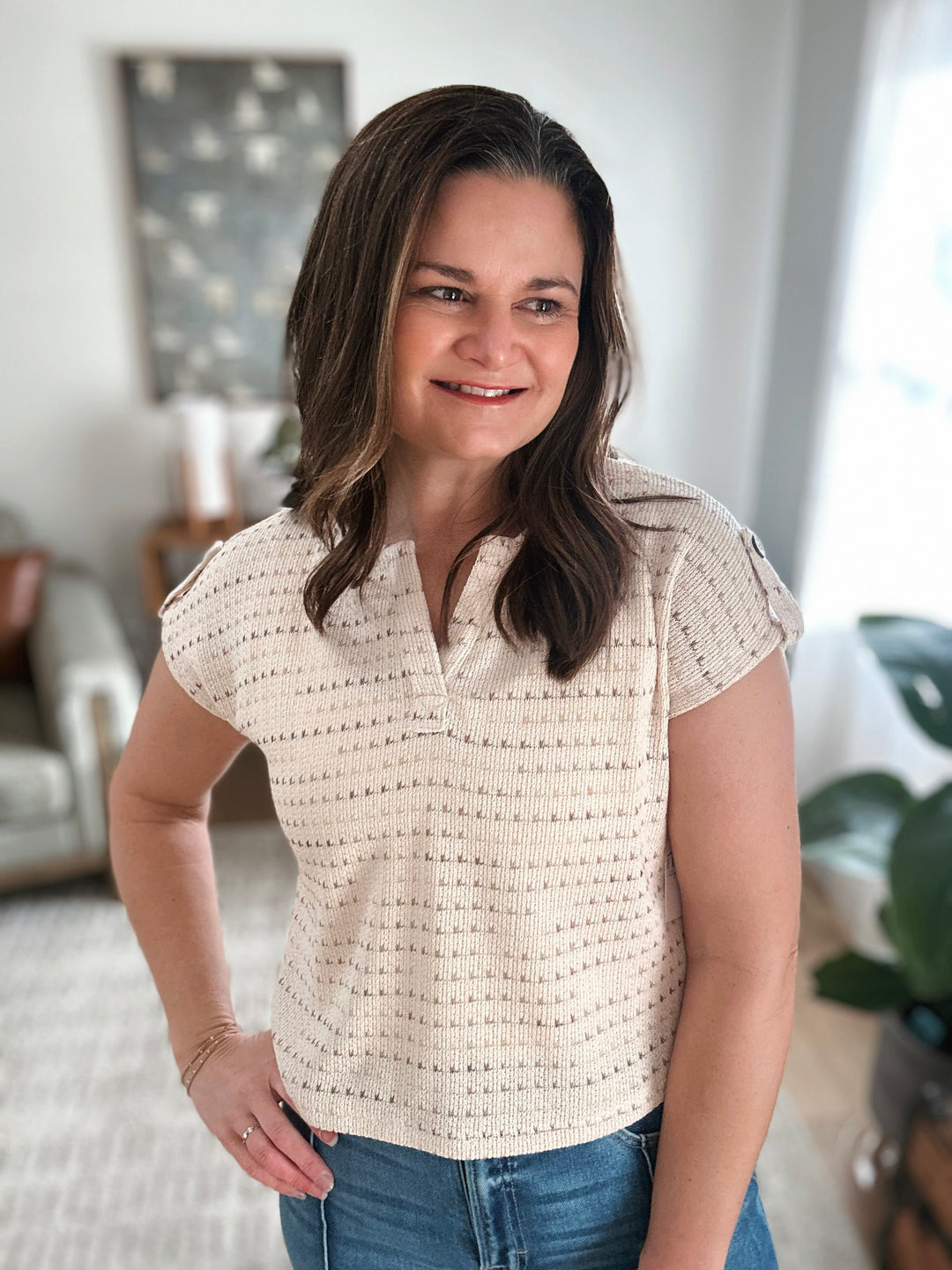 Woman wearing a textured white patterned top in a casual indoor setting