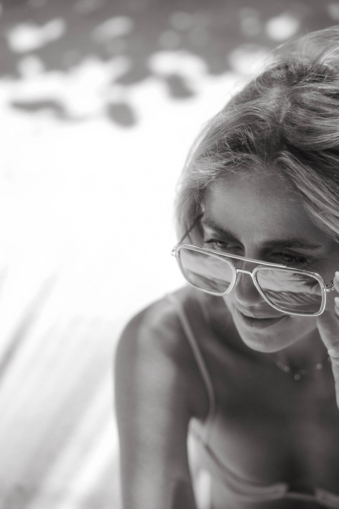 Black and white photo of a woman wearing glasses with a blurred background
