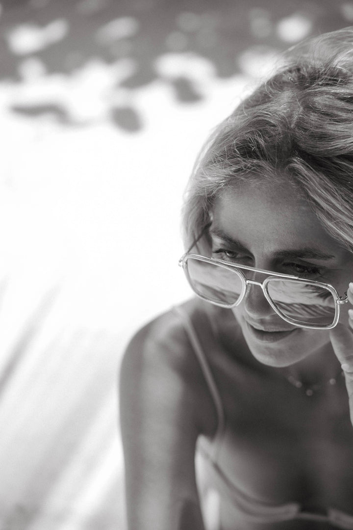 Black and white photo of a woman wearing glasses with a blurred background