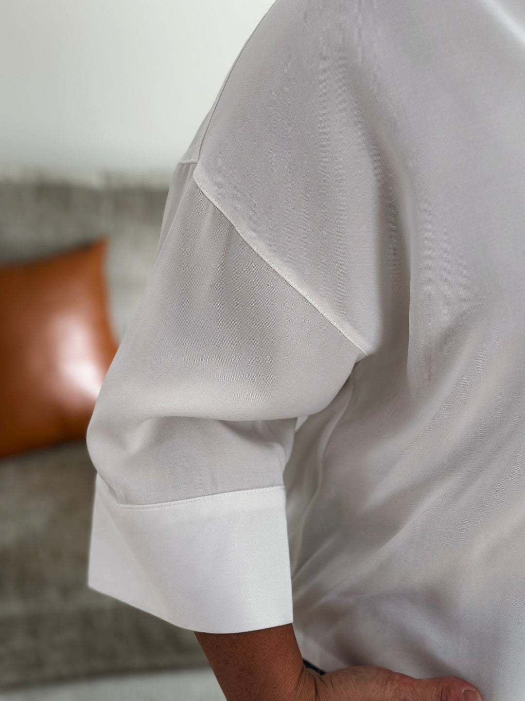 Close-up of a white shirt with rolled-up sleeves against a blurred background