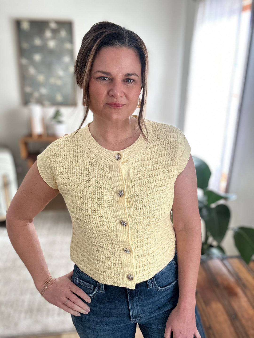 Woman wearing a yellow textured vest in a home setting