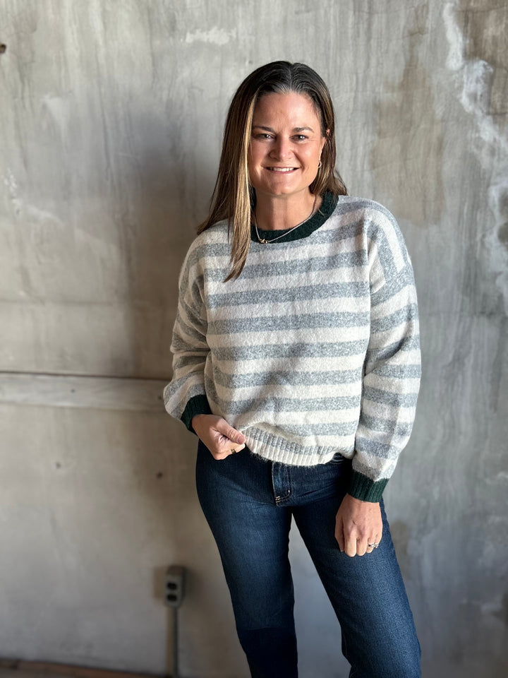 Woman in a gray and cream striped crewneck sweater, full-length view