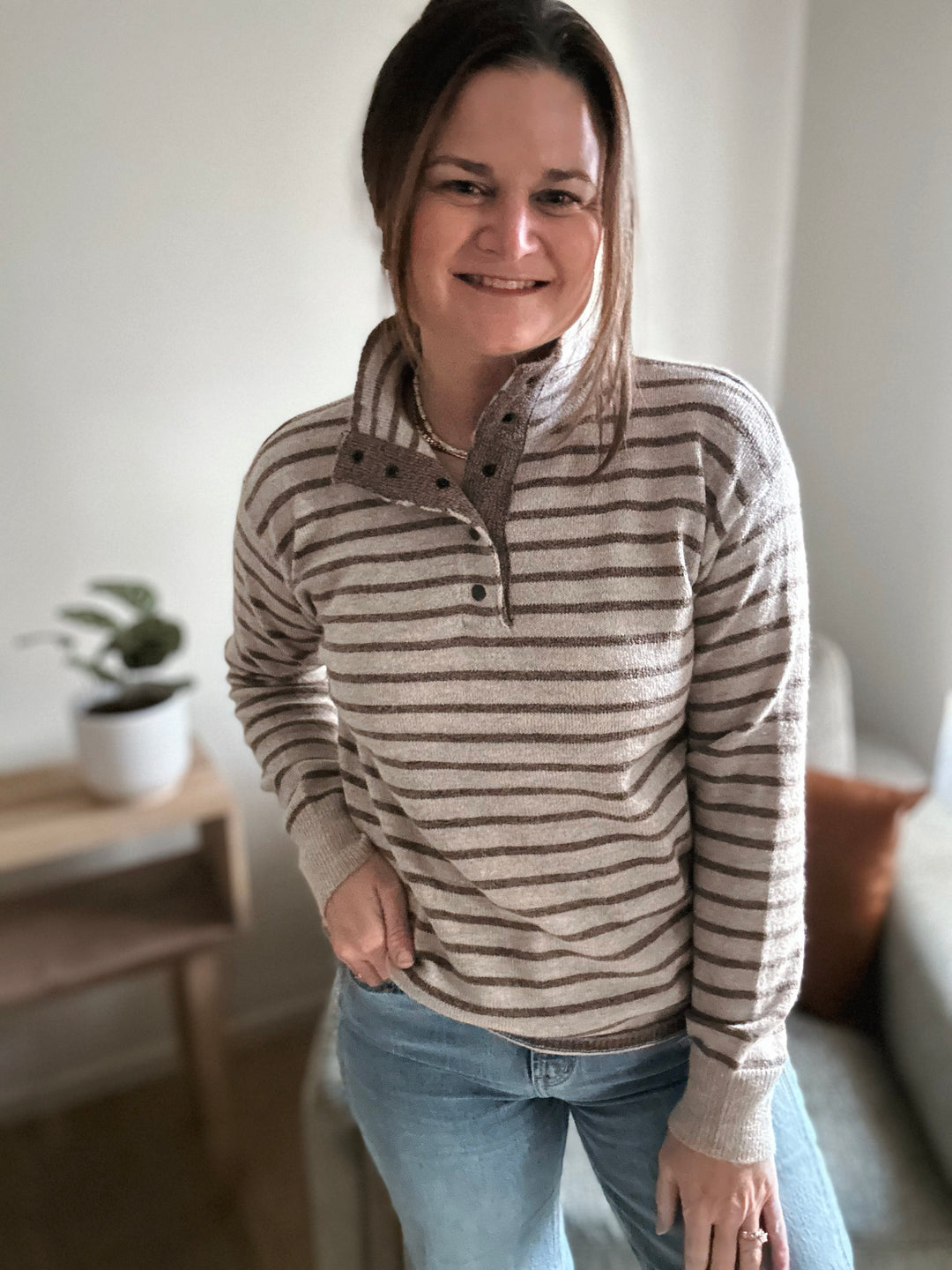 Woman wearing a striped sweater and jeans in a home setting