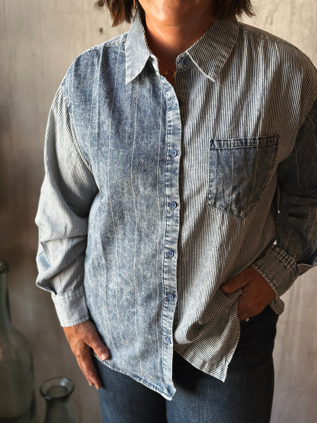 Person wearing a striped shirt with a neutral background