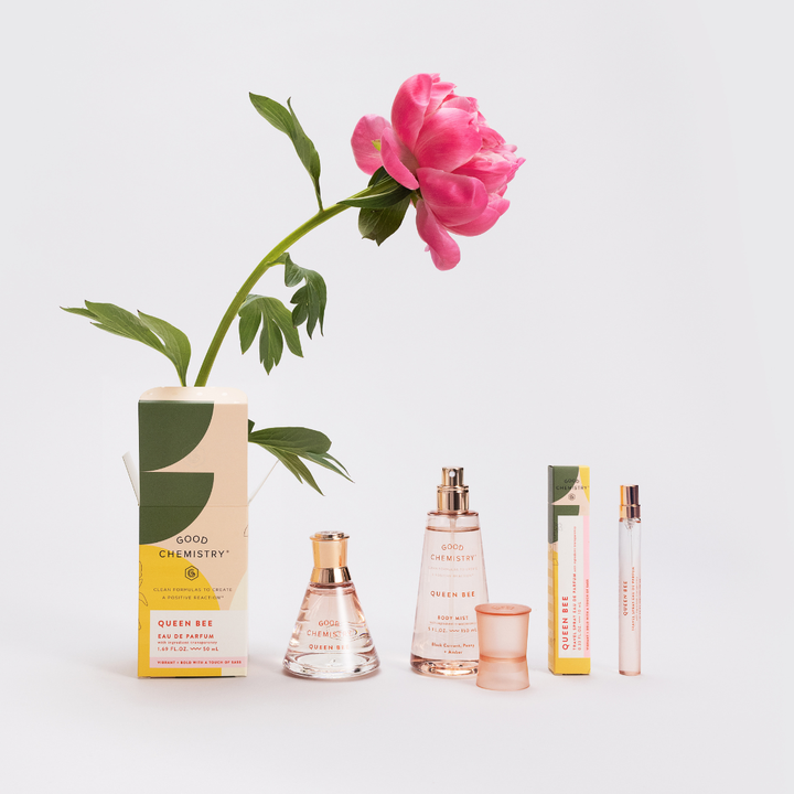 Perfume bottles and packaging with a pink flower on a light gray background