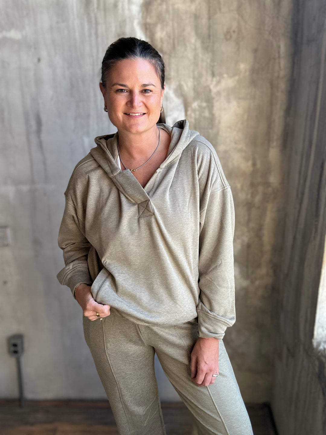 Woman wearing khaki jogger pants with a matching half-zip pullover