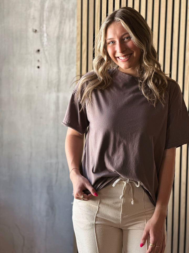 Front view of model wearing brown relaxed, oversized fit and raw edge details t-shirt