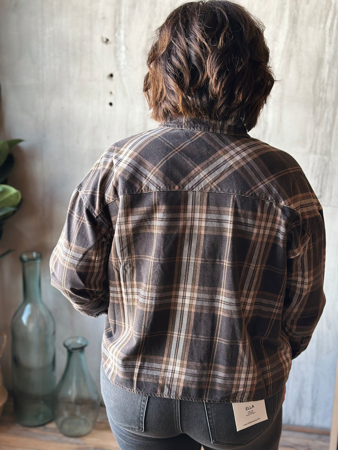 Person wearing a plaid shirt with a neutral background