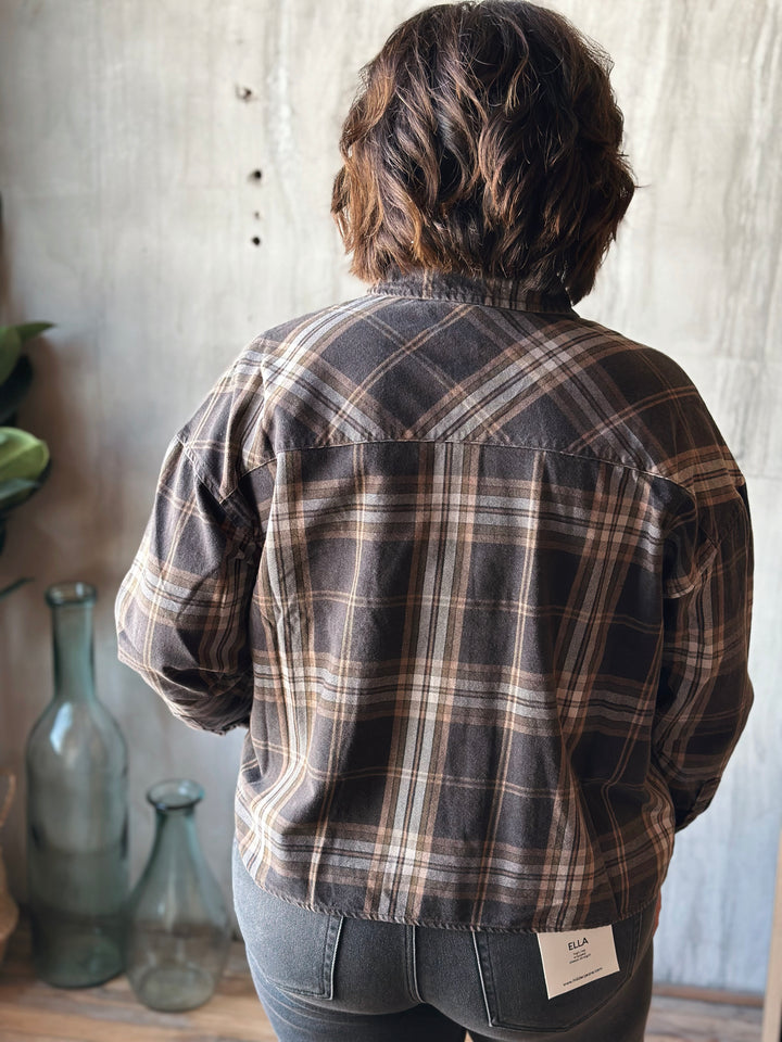 Person wearing a plaid shirt with a neutral background