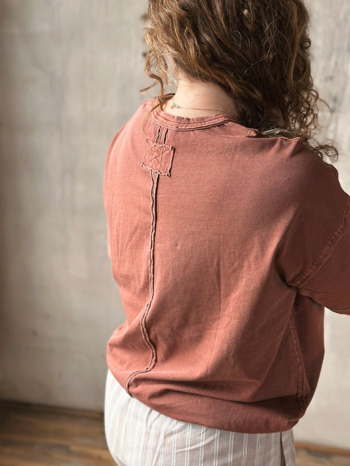 Person wearing a brown shirt with a neutral background