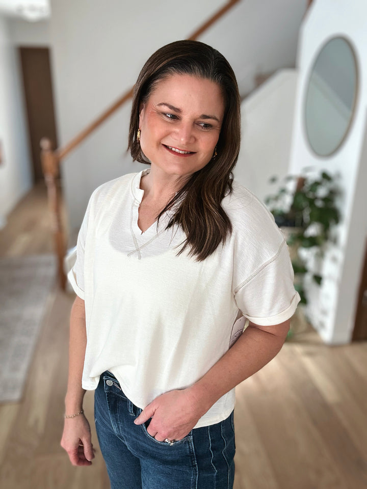 Woman wearing a white shirt and blue jeans indoors