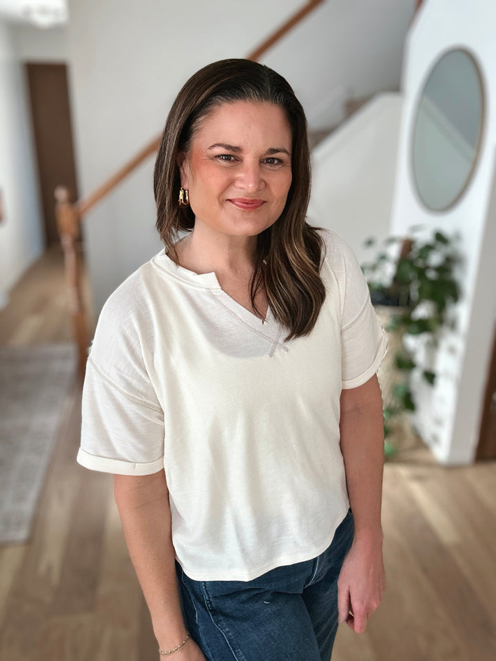 Woman wearing a white t-shirt and blue jeans indoors