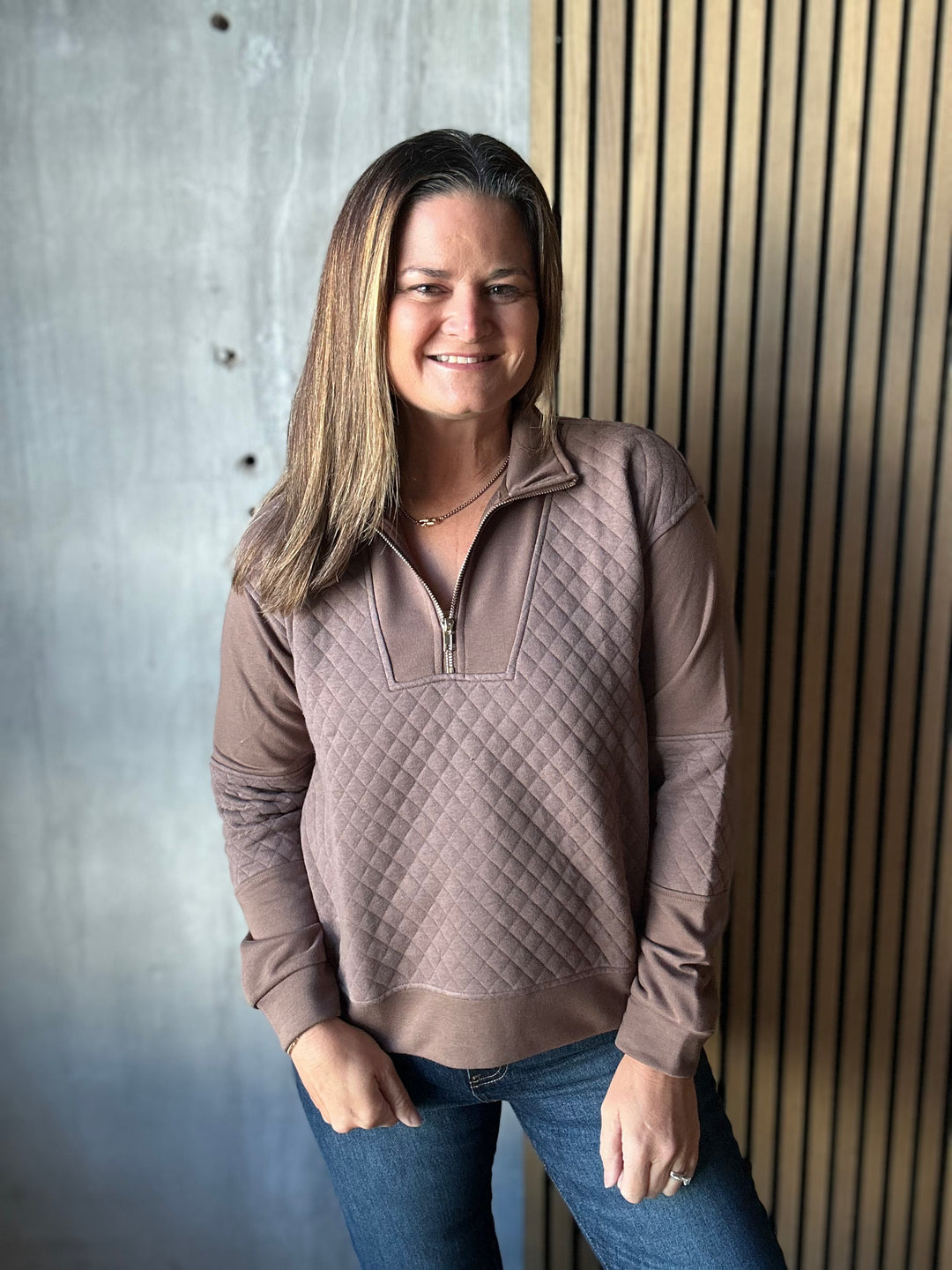 Mocha brown quilted half-zip pullover styled with dark jeans