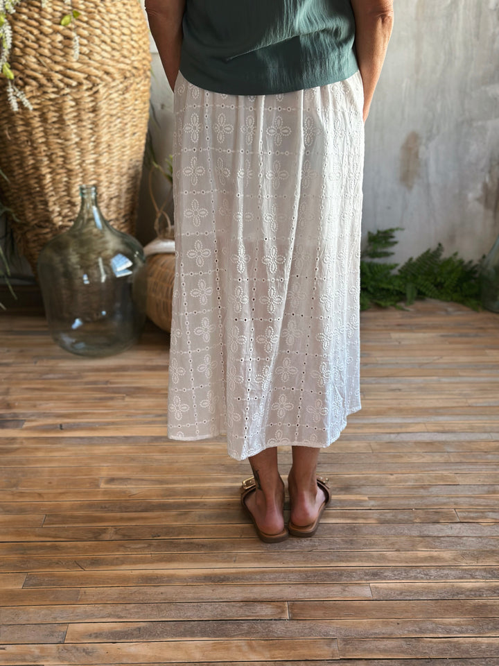 back view white eyelet midi skirt,  Featuring a high elastic waist with a front tie drawstring, delicate ruffle trim, and a classic eyelet pattern.